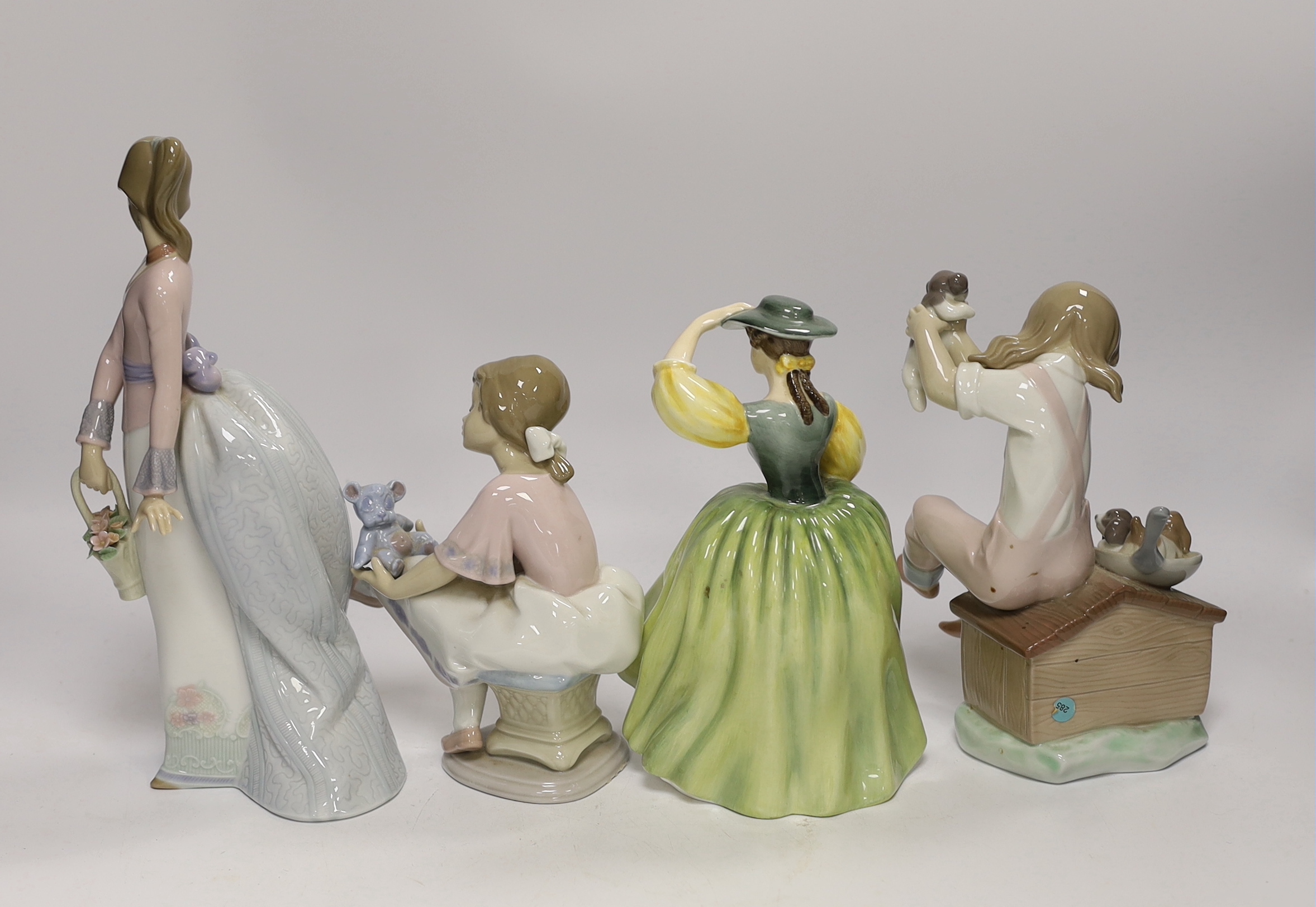 A Lladro recumbent clown, three smaller Lladro figures and a Royal Doulton Buttercup figure, clown 37.7cm wide (5)